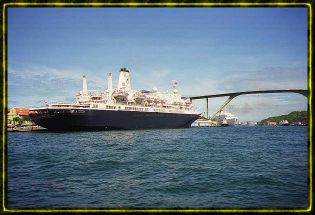 The MS Nieuw Amsterdam in front of the Queen Juliana Bridge in the harbor at Willemsted