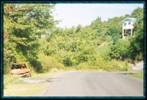 Burned out car on the road to Marigot Bay